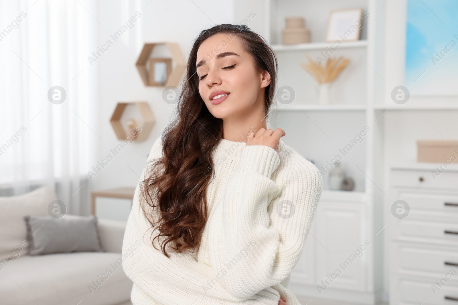 Photo of Beautiful young woman in stylish warm sweater at home