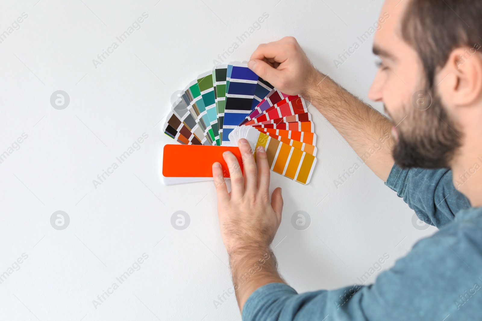 Photo of Young man with color palette on white background
