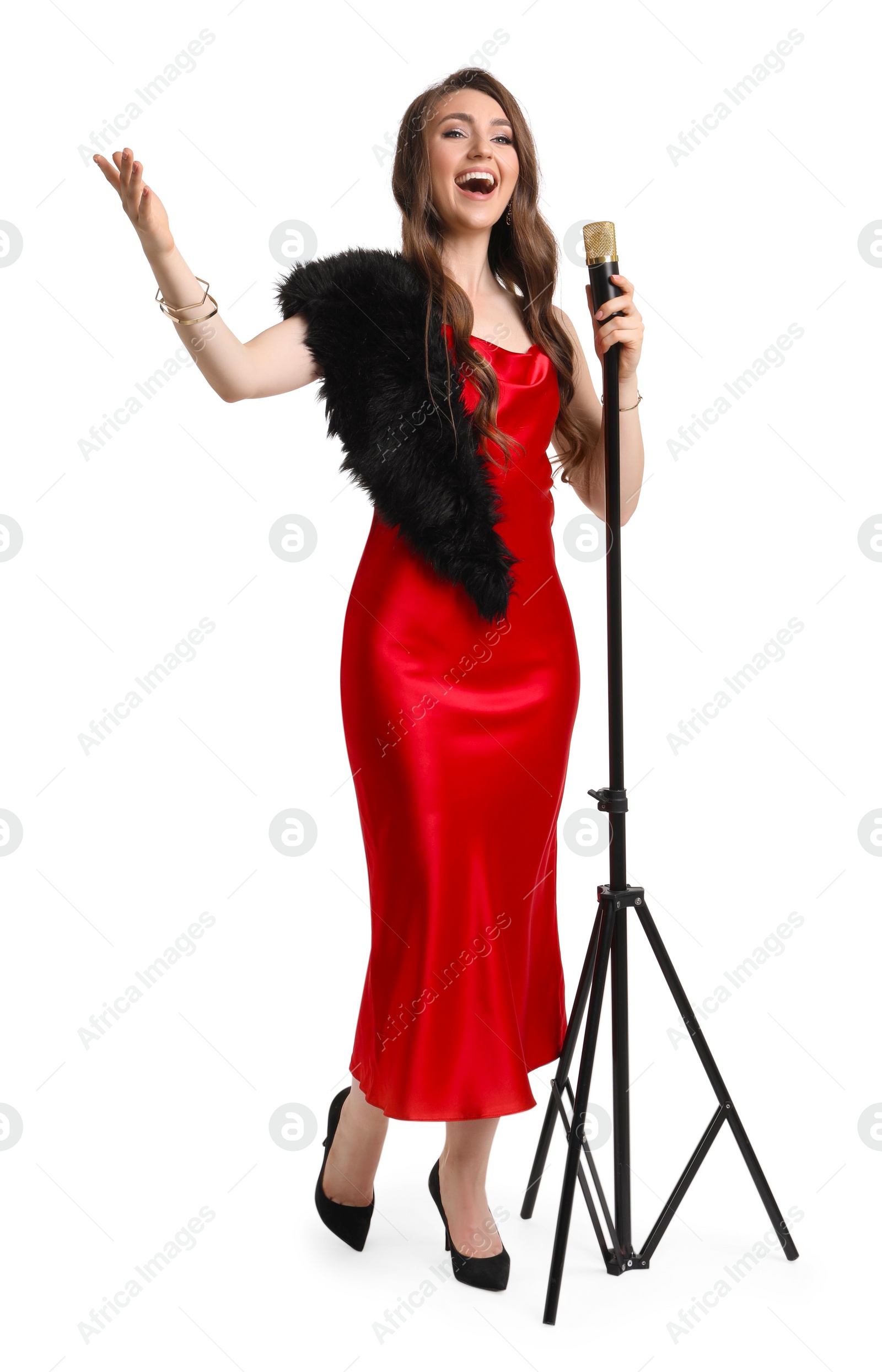 Photo of Beautiful young woman in stylish red dress with microphone singing on white background