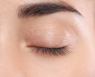 Photo of Young woman with beautiful natural eyelashes, closeup view