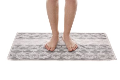 Man standing on stylish bath mat against white background, closeup