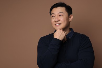 Portrait of happy man on brown background. Space for text