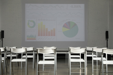 Empty conference room with projection screen and chairs