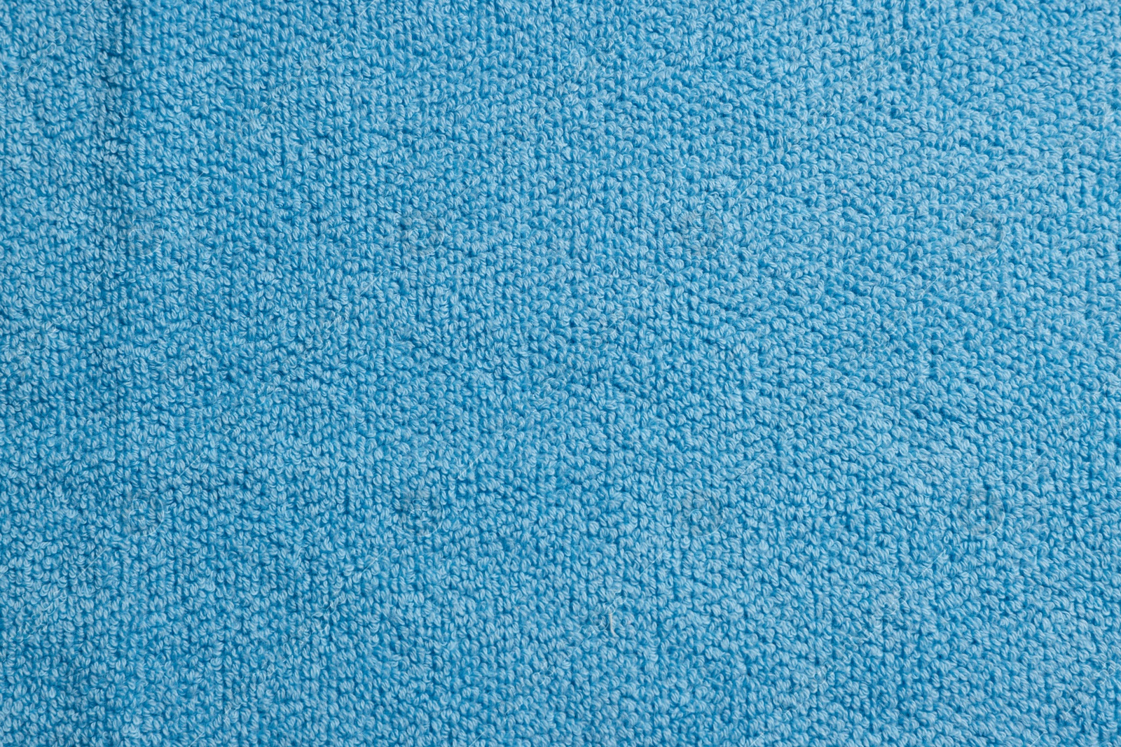 Photo of Soft blue towel as background, top view