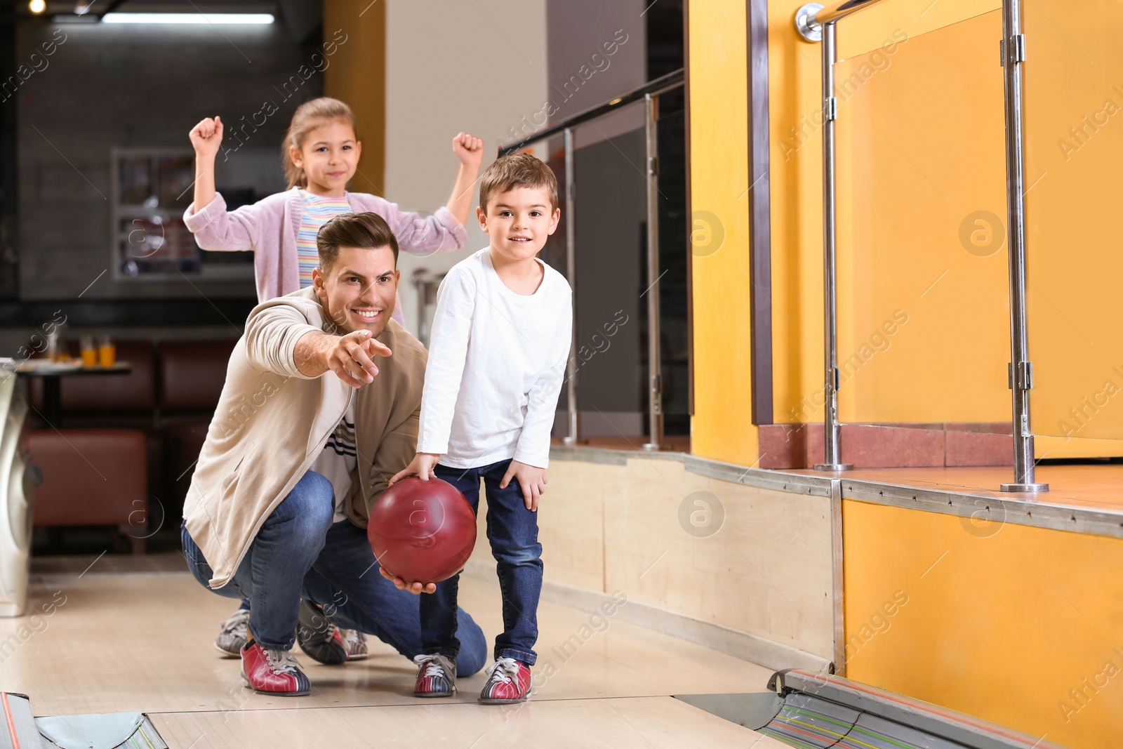 Photo of Happy family spending time together in bowling club