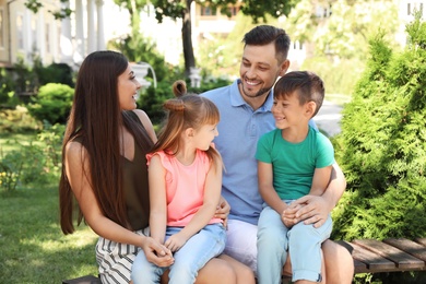 Happy family with children together on bench in park