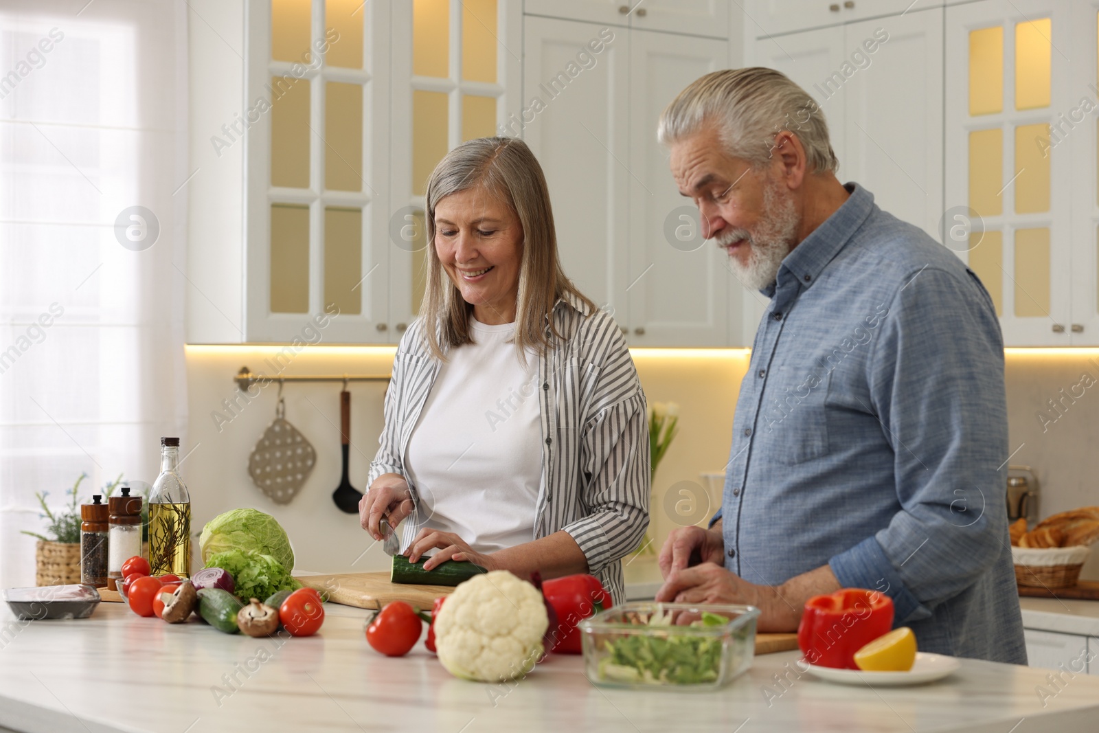 Photo of Happy senior couple cooking together in kitchen