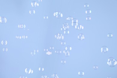 Beautiful transparent soap bubbles on light grey background