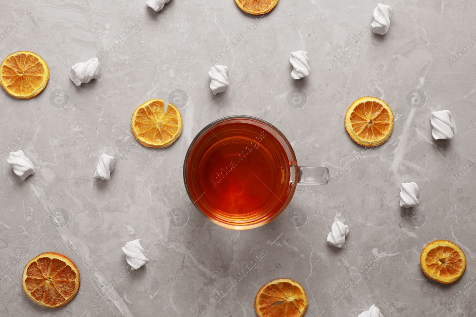 Photo of Flat lay composition with cup of tea on grey marble table. Cozy winter