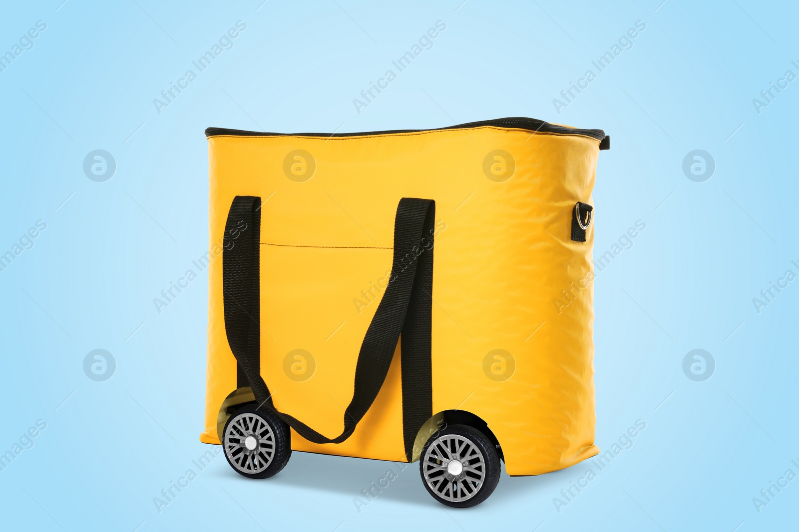 Image of Yellow thermo bag on wheels against light blue background. Food delivery service