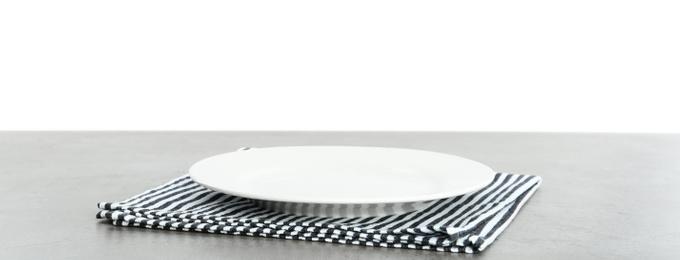 Photo of Empty plate and napkin on grey table