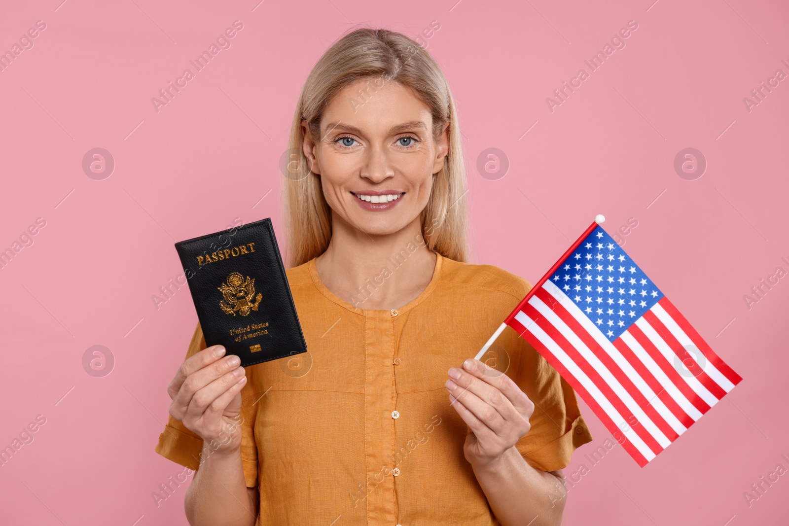 Photo of Immigration. Happy woman with passport and American flag on pink background