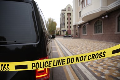 Image of Yellow crime scene tape near car outdoors