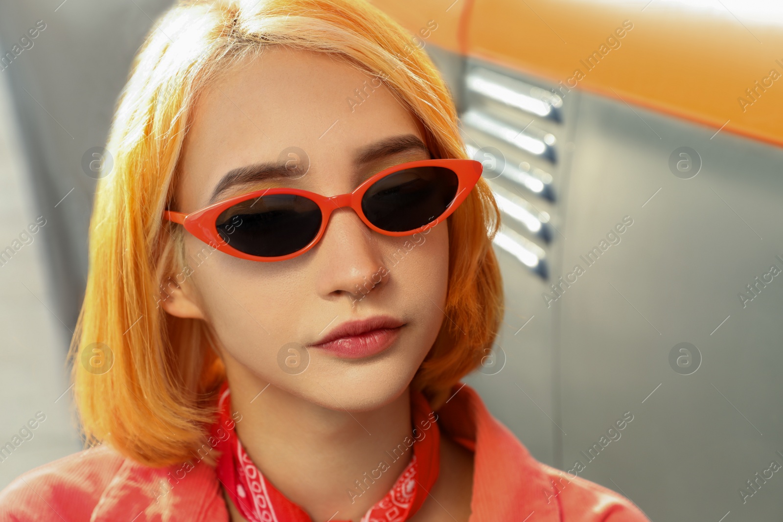 Photo of Beautiful young woman with bright dyed hair in sunglasses outdoors