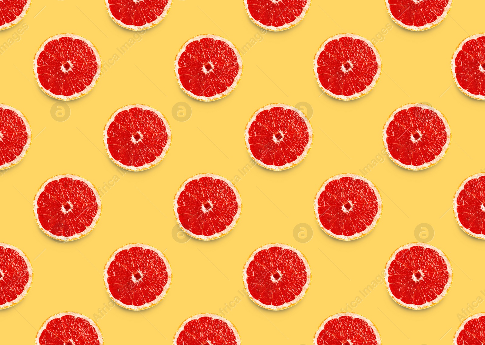 Image of Many fresh ripe slices of grapefruits on yellow background, flat lay. Seamless pattern design