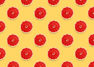Image of Many fresh ripe slices of grapefruits on yellow background, flat lay. Seamless pattern design
