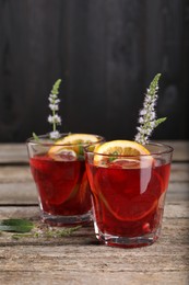 Photo of Glasses of delicious refreshing sangria on old wooden table
