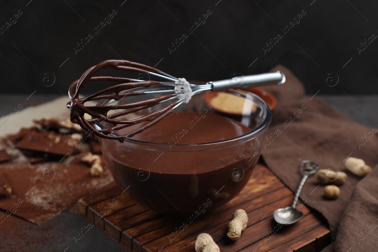 Photo of Bowl of chocolate cream and whisk on table, closeup