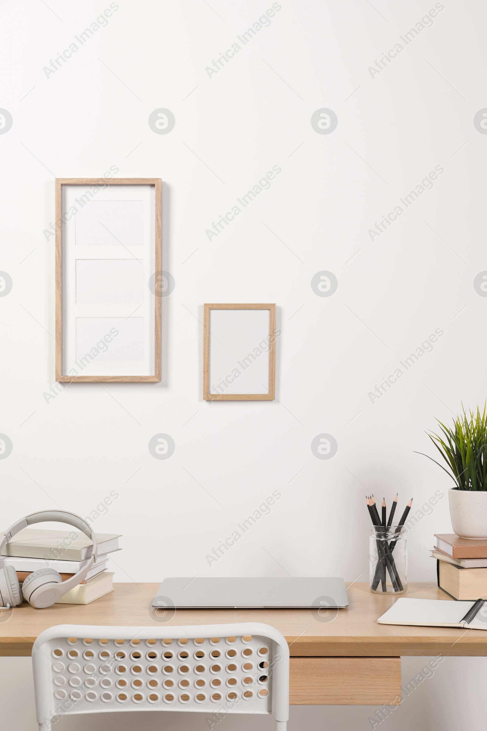 Photo of Cozy workspace with laptop and stationery on wooden desk at home