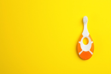 Manual toothbrush for child on color background, top view with space for text