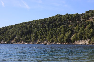 Picturesque view of beautiful sea and mountain with trees outdoors