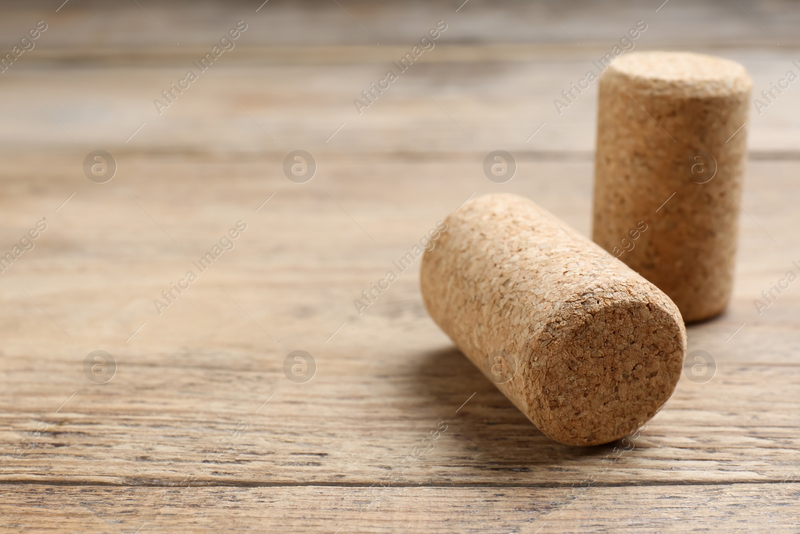 Photo of Corks of wine bottles on wooden table, closeup. Space for text