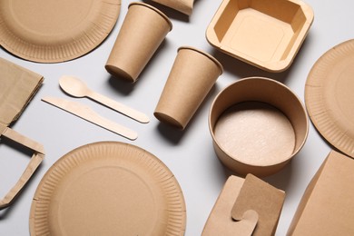 Eco friendly food packaging. Paper containers and tableware on light grey background, above view