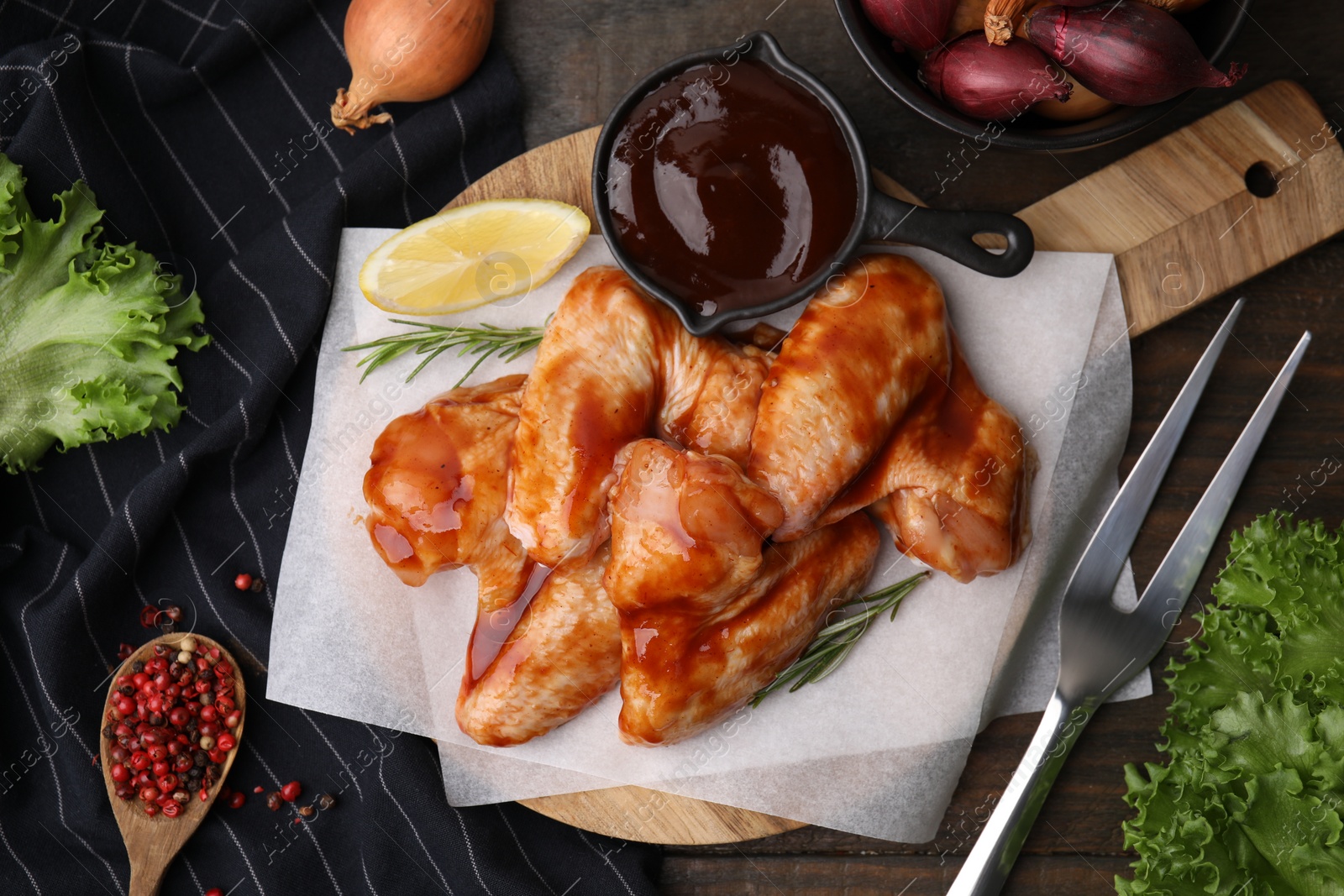 Photo of Flat lay composition with marinade, raw chicken wings and other products on wooden table