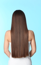 Woman with long brown hair on color background