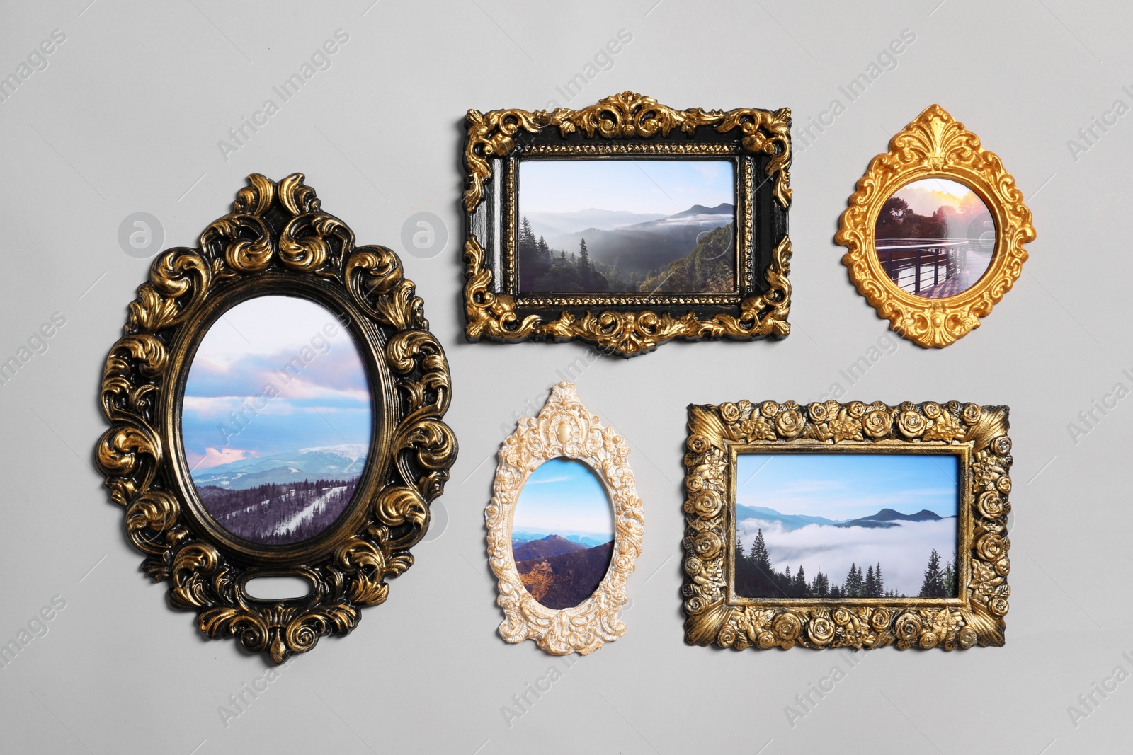 Photo of Vintage frames with beautiful photos of landscapes hanging on light gray wall