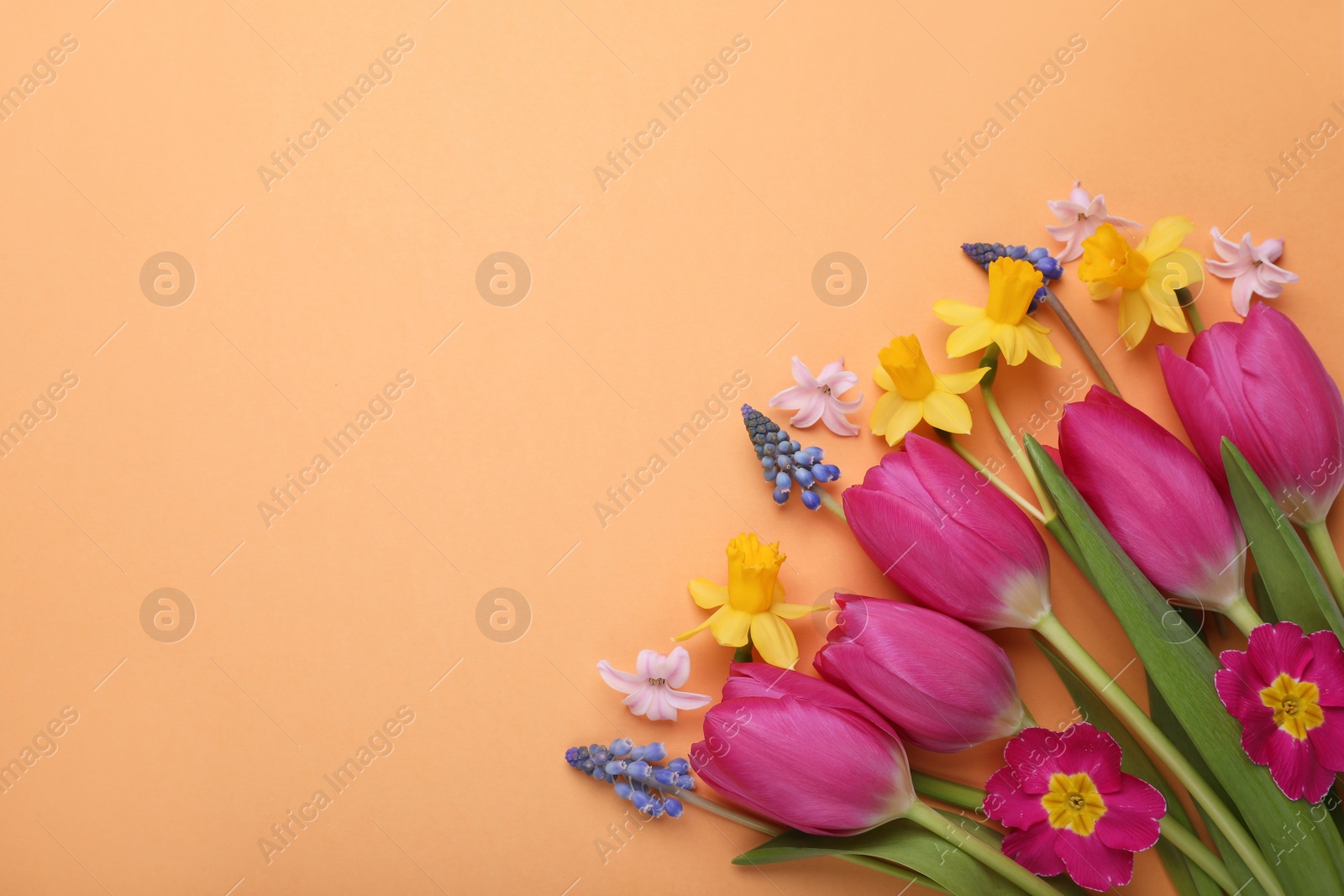 Photo of Beautiful bouquet with different flowers on orange background, flat lay. Space for text