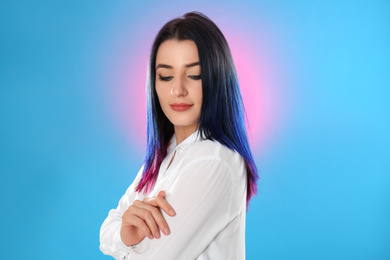 Photo of Young woman with bright dyed hair on color background