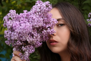 Photo of Attractive young woman near blooming lilac bush outdoors, closeup