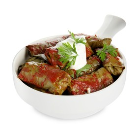 Photo of Delicious stuffed grape leaves with sour cream and tomato sauce on white background