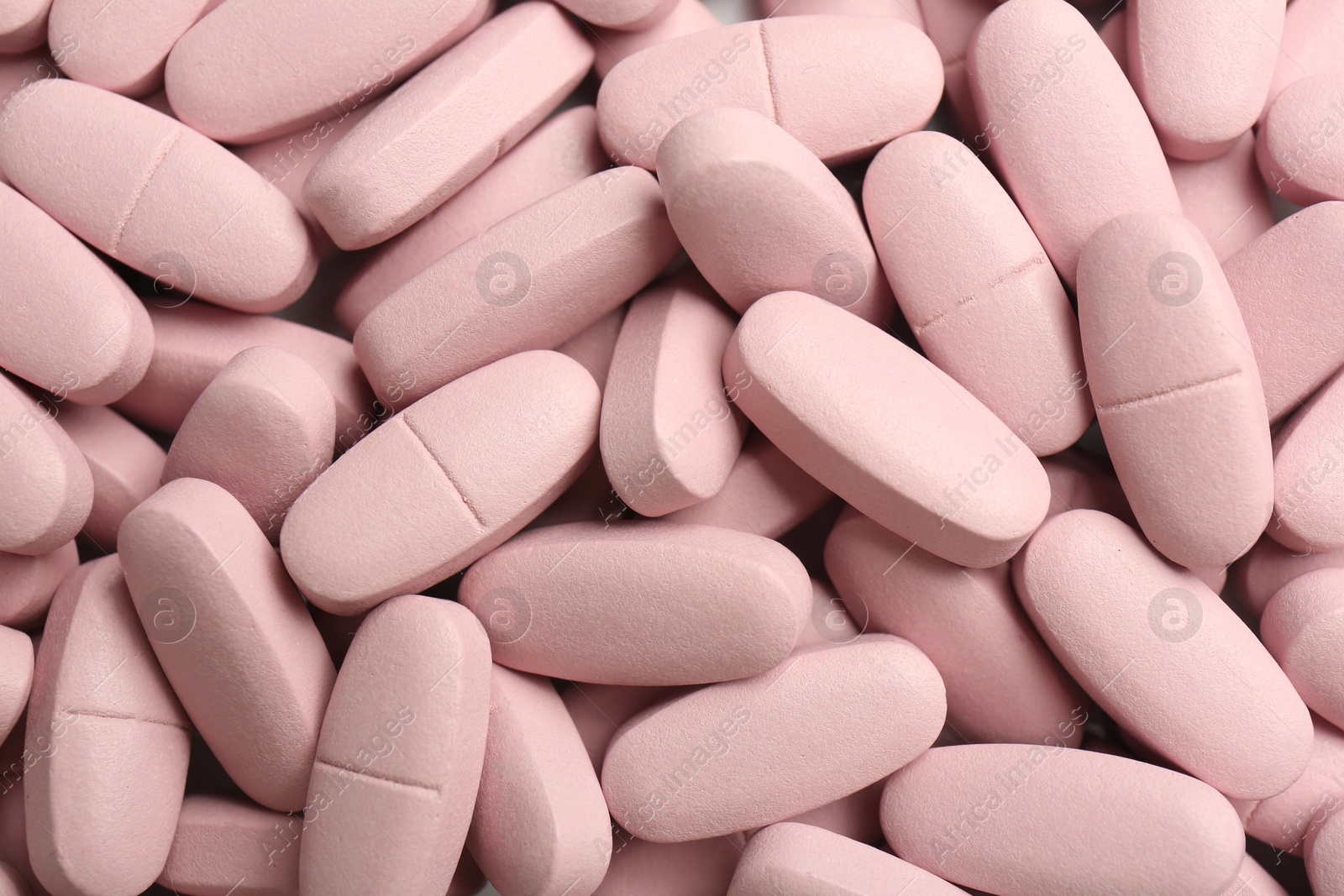 Photo of Pink vitamin capsules as background, top view