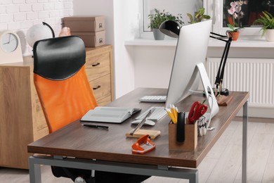 Photo of Stylish director's workplace with comfortable furniture, computer and accessories in office. Interior design