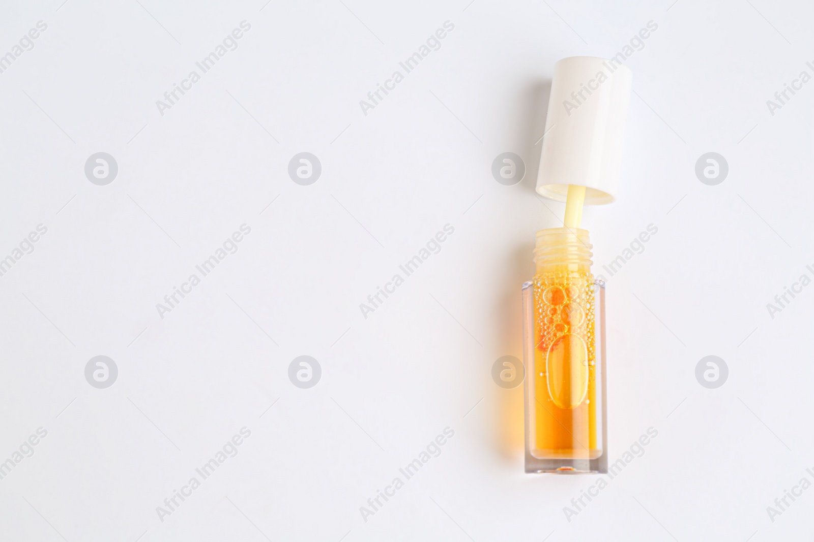 Photo of Orange lip gloss on white background, top view. Space for text