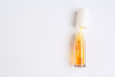 Photo of Orange lip gloss on white background, top view. Space for text