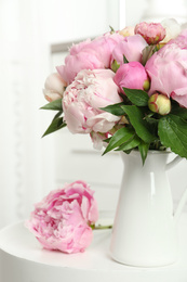 Photo of Bouquet of beautiful peonies in vase on white table