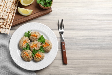 Photo of Flat lay composition with plate of traditional Passover (Pesach) gefilte fish on wooden background. Space for text