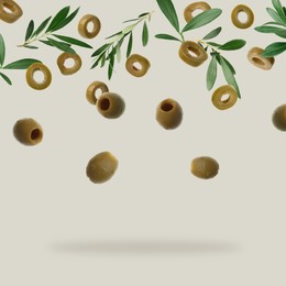 Image of Fresh olives and leaves falling on light grey background