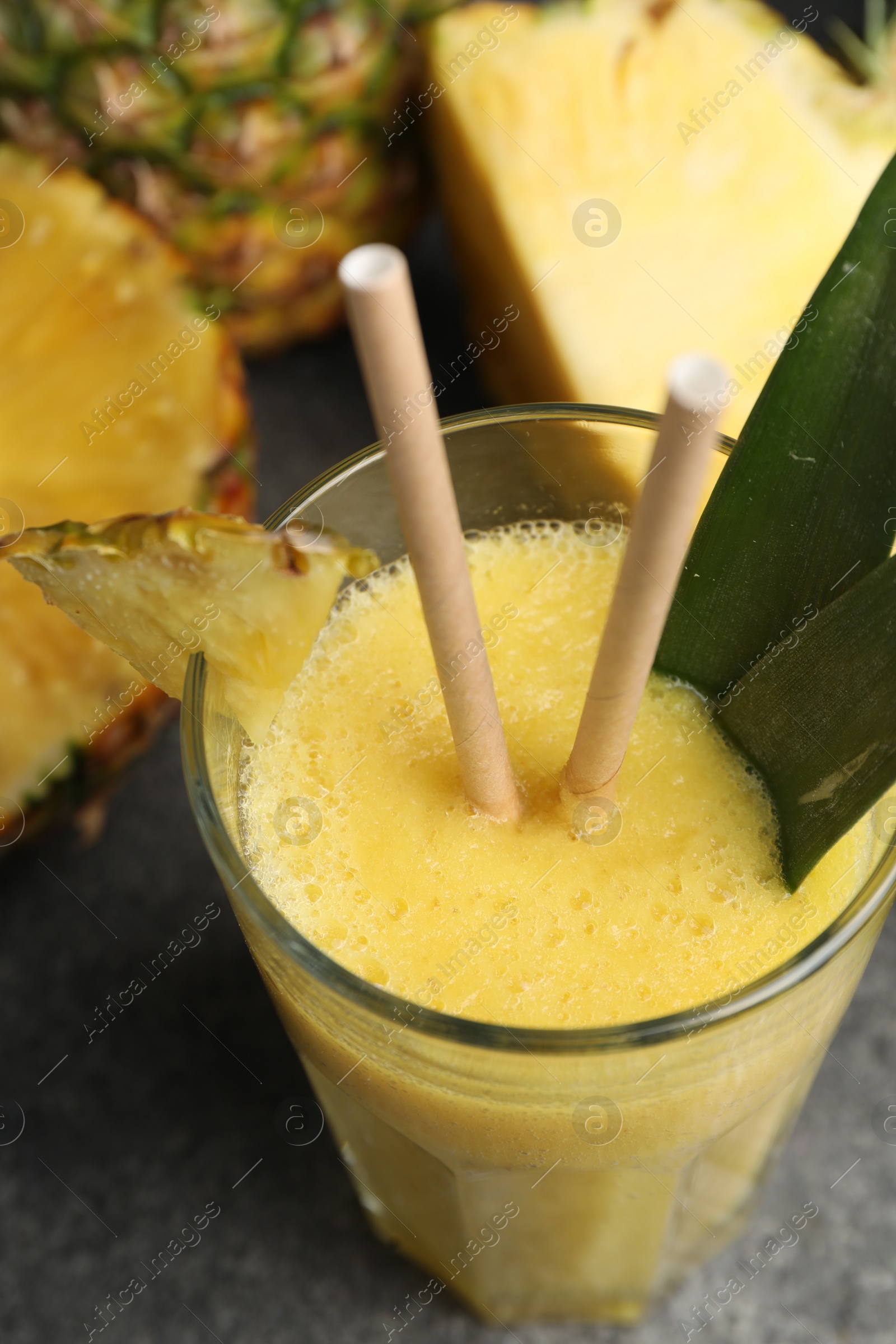 Photo of Tasty pineapple smoothie and fruit on grey table, above view