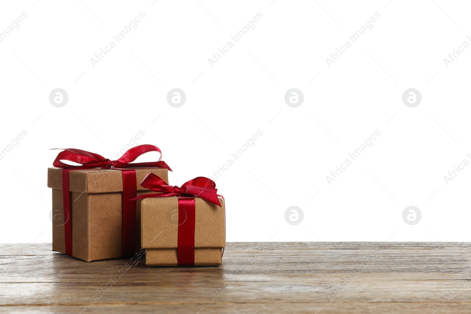 Photo of Christmas gifts in kraft boxes on wooden table against white background. Space for text