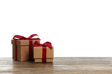 Photo of Christmas gifts in kraft boxes on wooden table against white background. Space for text