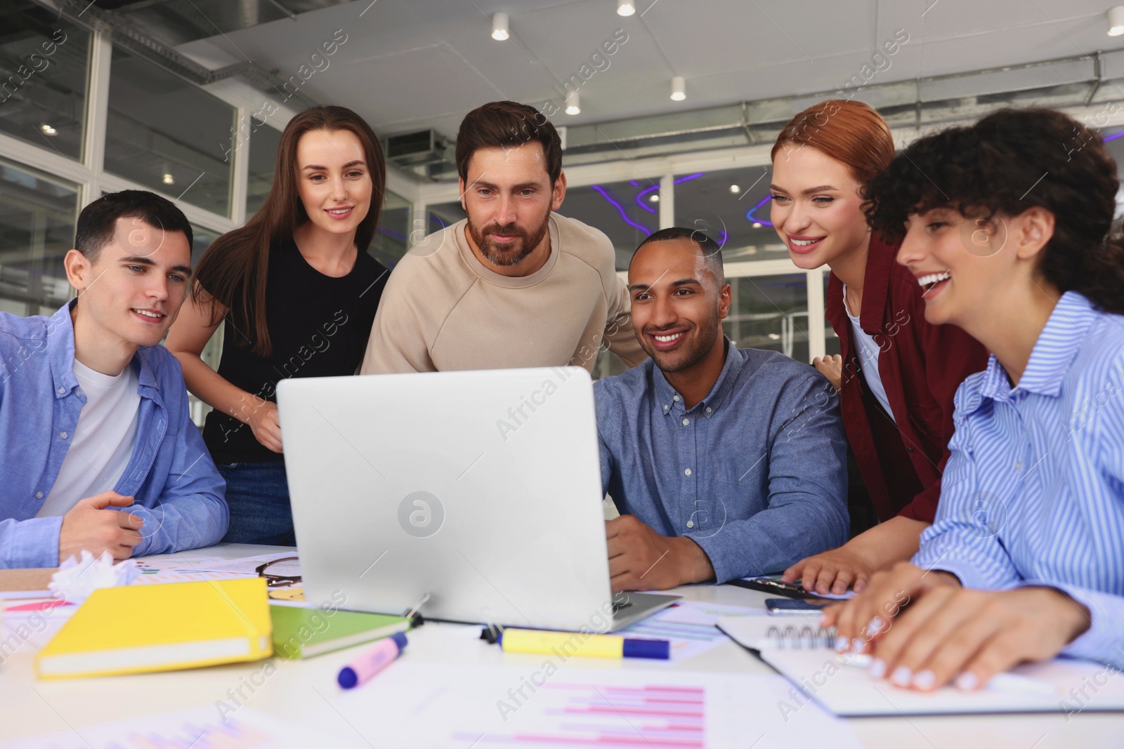 Photo of Team of employees working together at table in office. Startup project