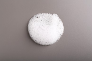 Photo of White foam with bubbles on grey background, top view