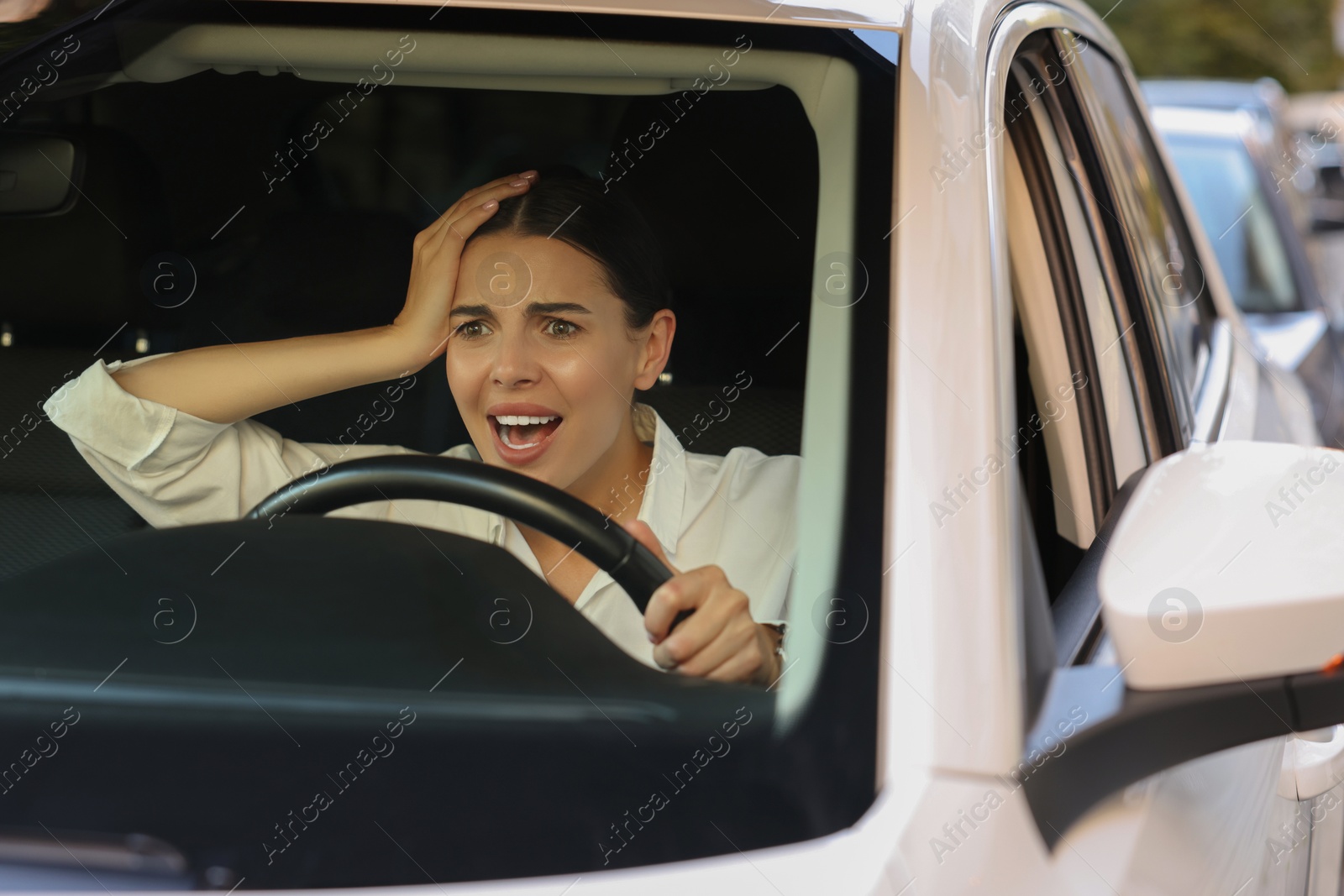 Photo of Stuck in traffic jam. Angry driver in her car, view through windshield