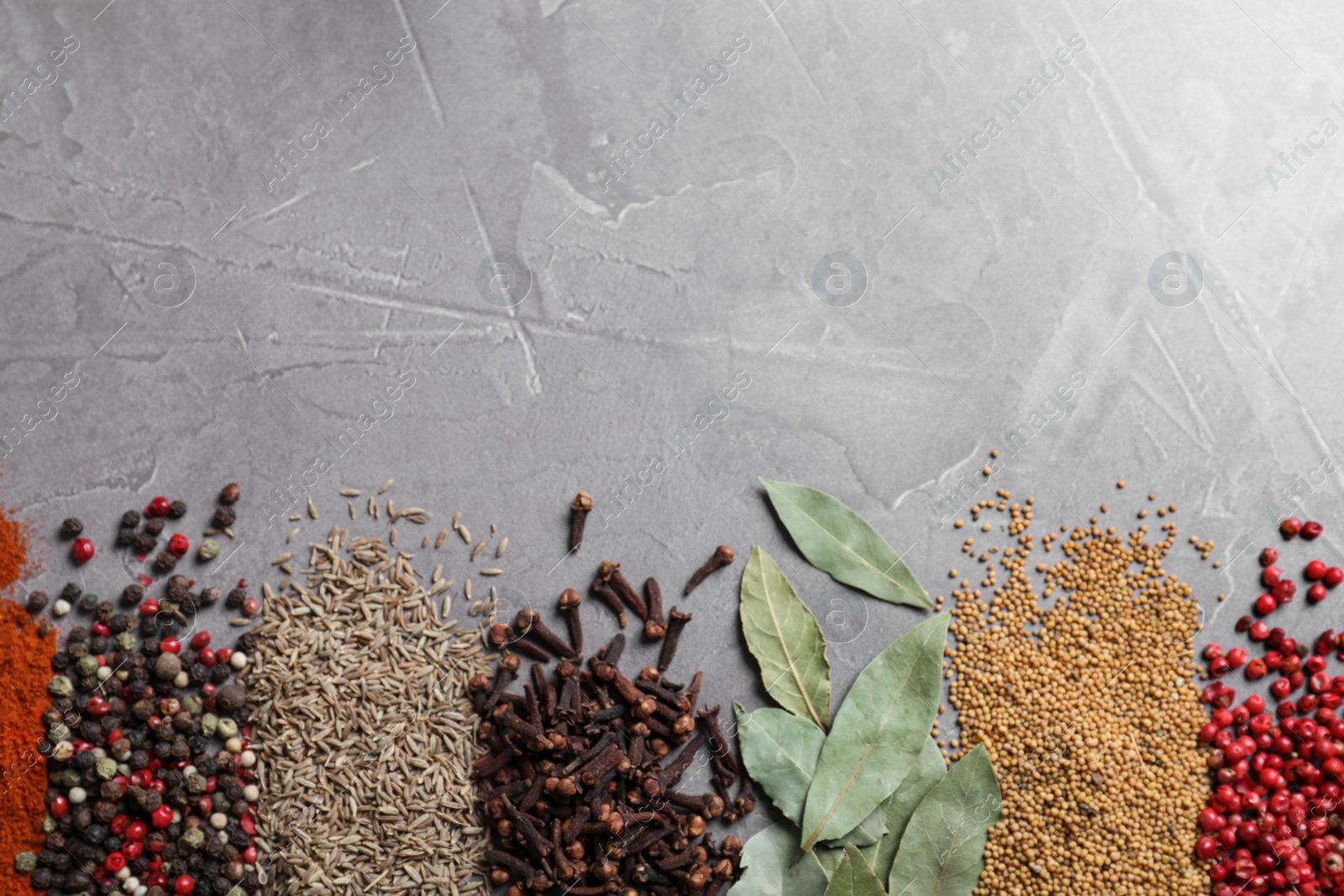 Photo of Different spices on grey background, top view. Space for text