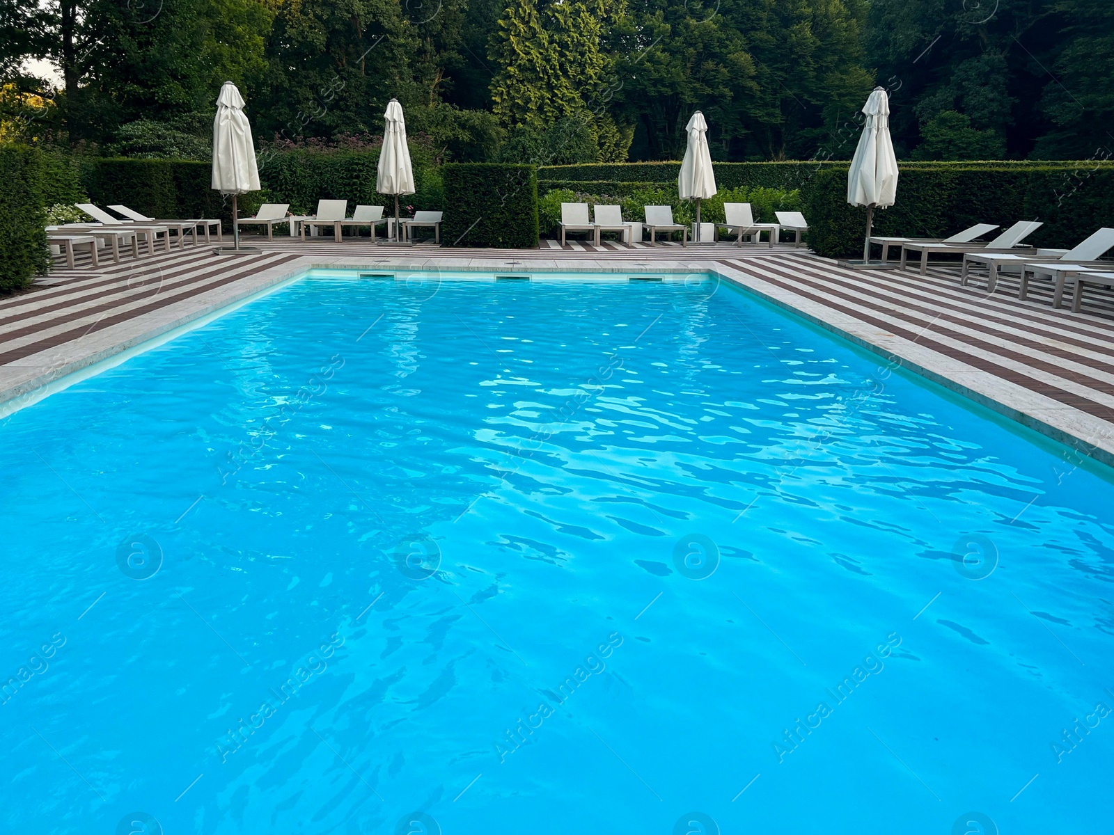 Photo of Outdoor swimming pool in luxury hotel on sunny summer day. Time for relax