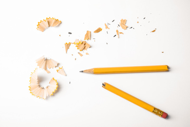 Broken pencil and shavings on white background, top view